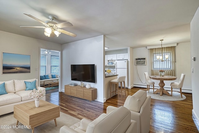 living area with ceiling fan with notable chandelier, baseboards, baseboard heating, a wall mounted air conditioner, and dark wood finished floors