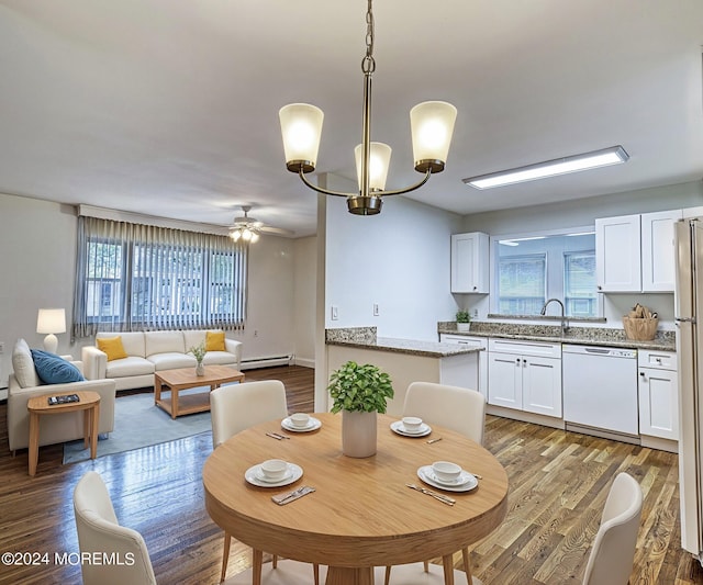 dining space featuring a baseboard heating unit, wood finished floors, and ceiling fan with notable chandelier