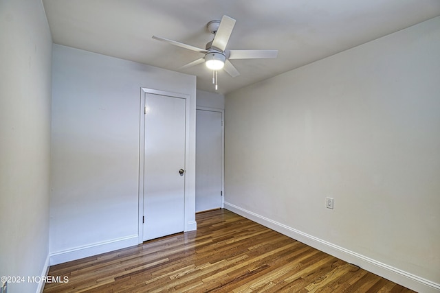 unfurnished bedroom with a ceiling fan, baseboards, and wood finished floors