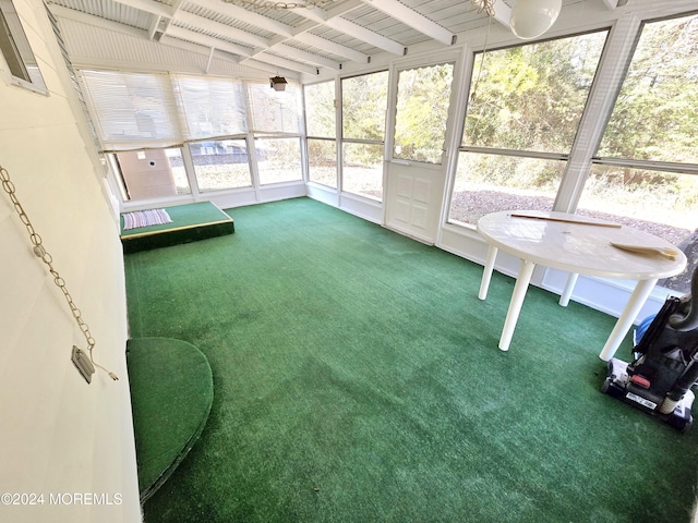 unfurnished sunroom featuring lofted ceiling with beams