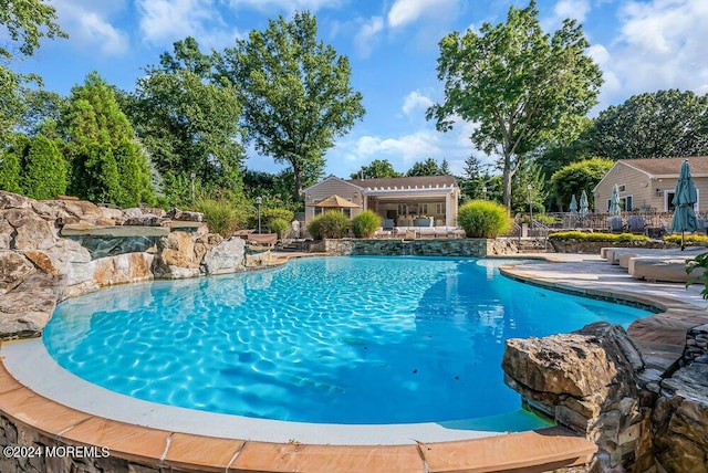 pool with a patio area and fence