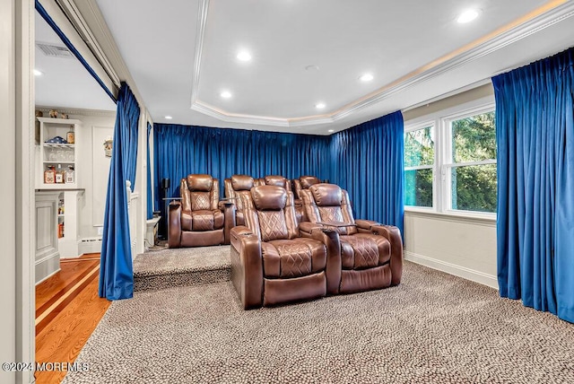 cinema room with recessed lighting, wood finished floors, visible vents, a raised ceiling, and crown molding