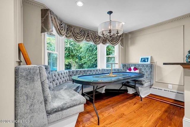 dining space featuring light wood-style floors, baseboard heating, plenty of natural light, and a notable chandelier