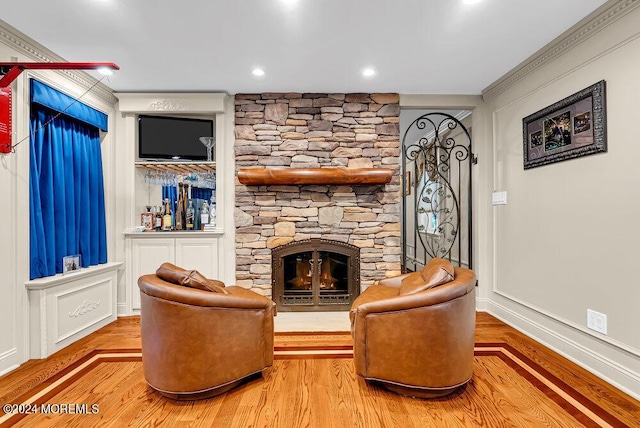 living room with a fireplace, a decorative wall, and wood finished floors