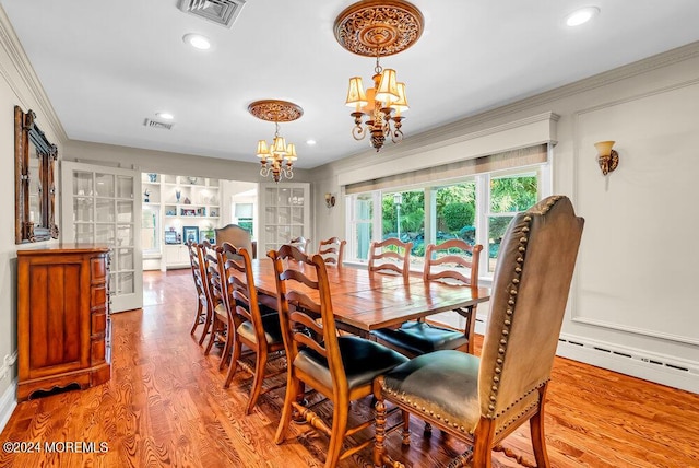 dining area with ornamental molding, wood finished floors, visible vents, and a notable chandelier