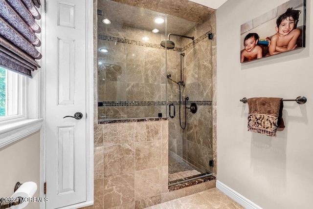 full bathroom featuring a stall shower and baseboards