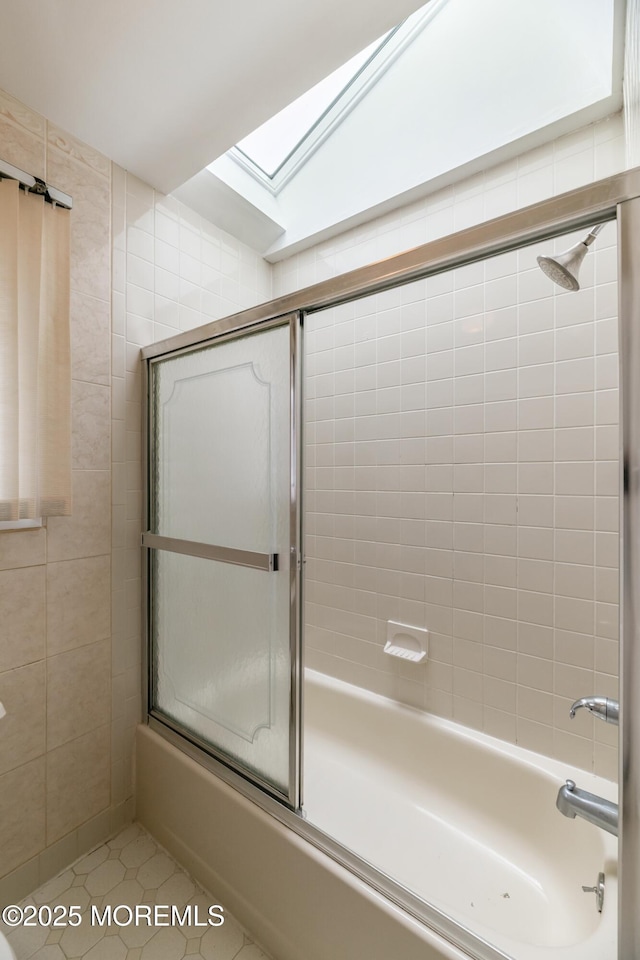 full bathroom with lofted ceiling with skylight, tile patterned flooring, and combined bath / shower with glass door