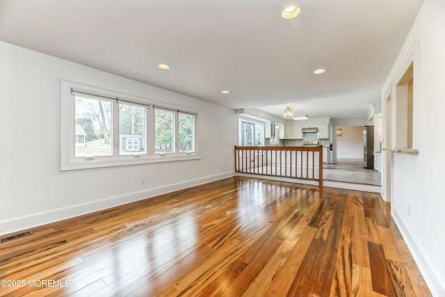 unfurnished room with baseboards, hardwood / wood-style floors, visible vents, and recessed lighting