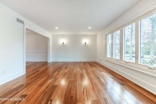 unfurnished room with recessed lighting, baseboards, visible vents, and light wood finished floors