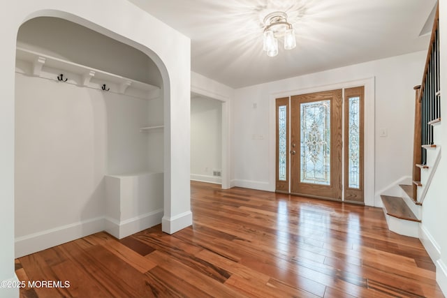 entryway with stairs, hardwood / wood-style floors, and baseboards