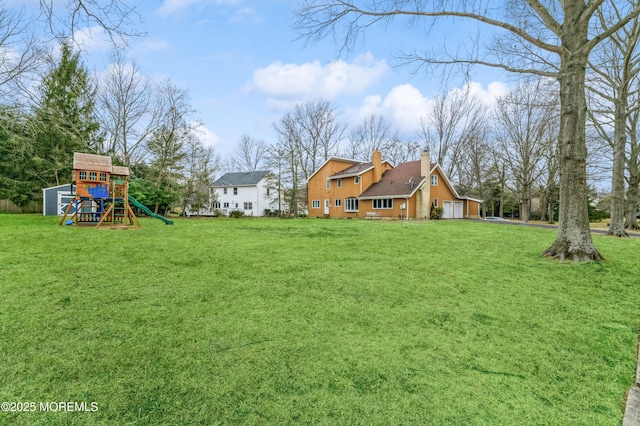 view of yard featuring a garage and a playground