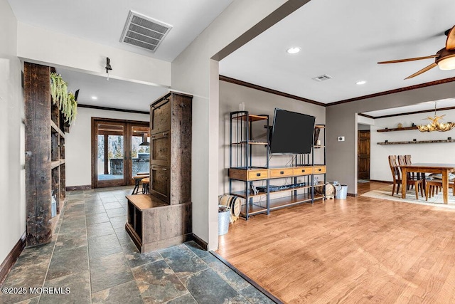 living room featuring visible vents, crown molding, and baseboards