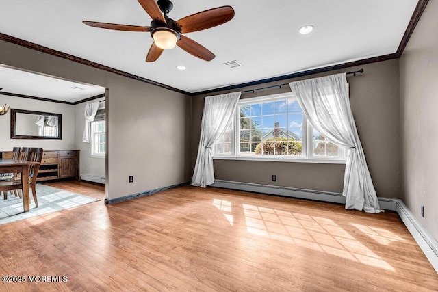 empty room with light wood-style flooring, visible vents, and crown molding