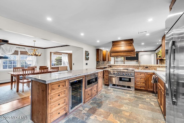 kitchen with crown molding, custom range hood, backsplash, built in appliances, and beverage cooler