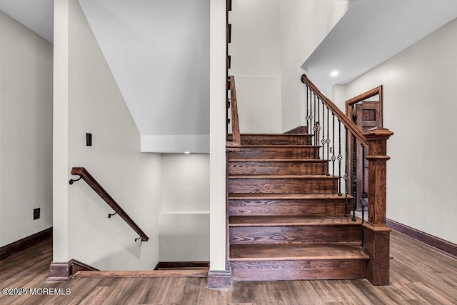 stairway with wood finished floors and baseboards