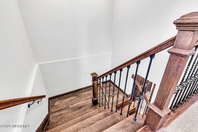 stairway featuring wood finished floors and baseboards