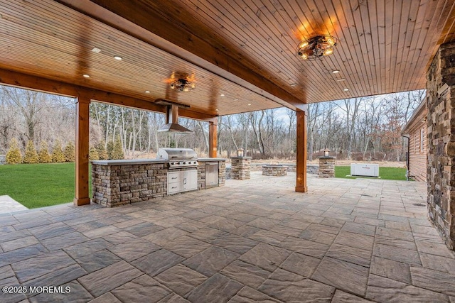 view of patio featuring a fire pit, an outdoor kitchen, and area for grilling