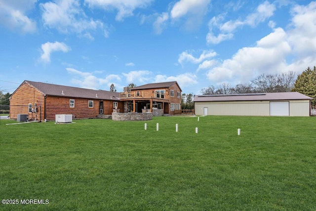 rear view of house with central AC, a yard, and an outdoor structure