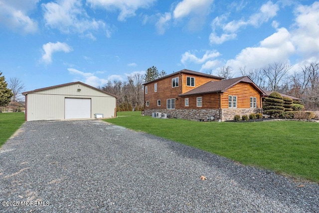 view of side of home featuring an outbuilding, a detached garage, a lawn, stone siding, and driveway