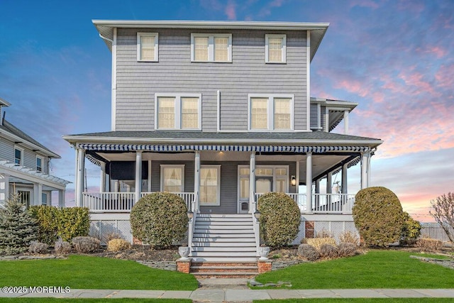 view of front of home with stairs, a porch, roof with shingles, and a front yard