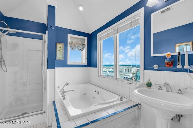 bathroom with a wainscoted wall, a stall shower, and visible vents