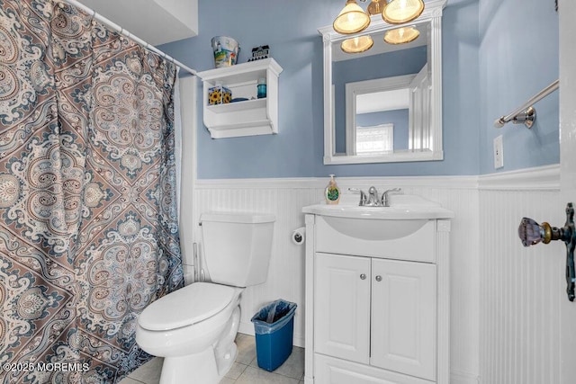 full bathroom with toilet, a wainscoted wall, vanity, and tile patterned floors