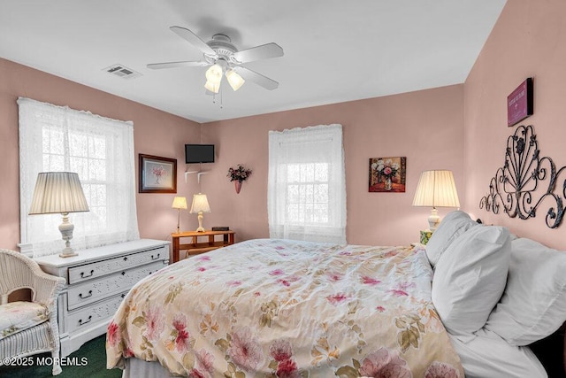 bedroom with carpet, visible vents, and a ceiling fan