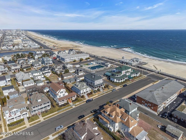 birds eye view of property featuring a beach view and a water view