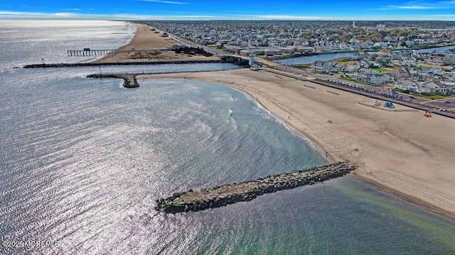 drone / aerial view featuring a water view and a view of the beach