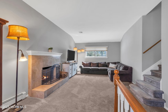 carpeted living area with stairway, visible vents, lofted ceiling, a tiled fireplace, and baseboard heating