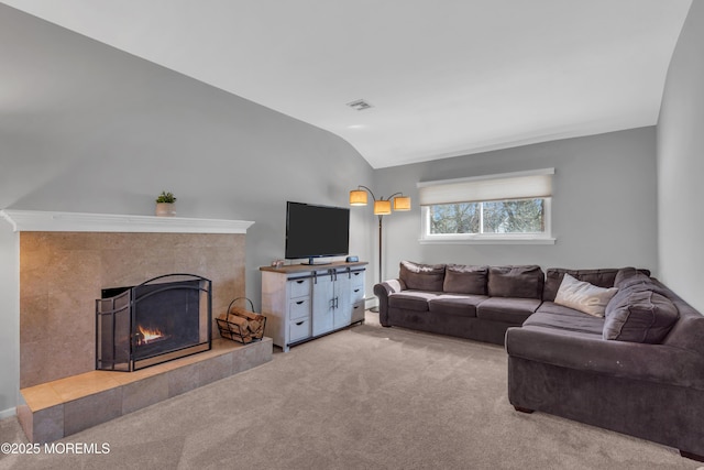 living room with visible vents, carpet flooring, a fireplace, and vaulted ceiling