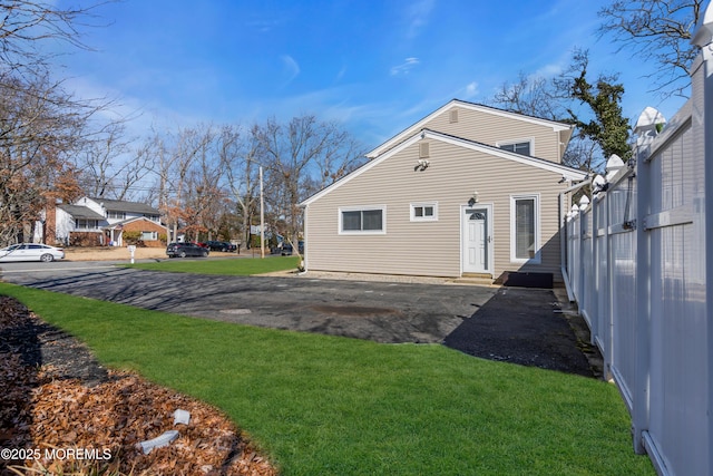 back of property featuring a yard and fence