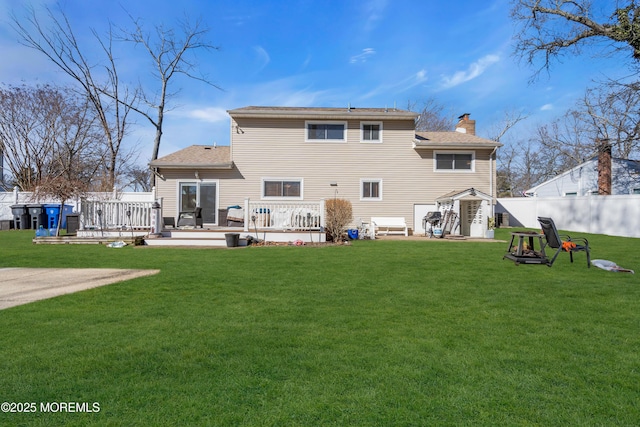 back of house with a lawn, a deck, and fence