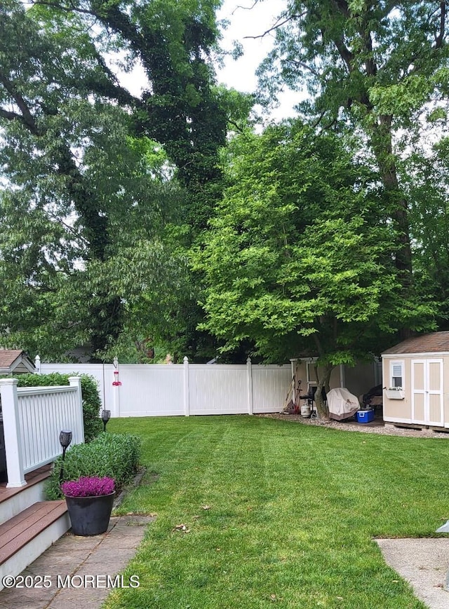 view of yard with an outbuilding, a shed, and fence