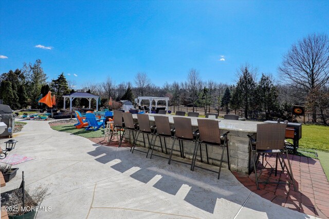 view of patio featuring fence, outdoor dry bar, a gazebo, and a pergola