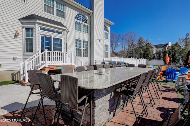 view of patio with fence and outdoor dry bar