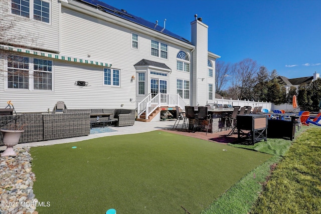 rear view of property with an outdoor hangout area, a patio, a chimney, and fence