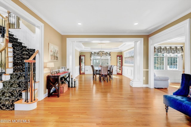 interior space with a healthy amount of sunlight, ornamental molding, stairway, and light wood-style floors