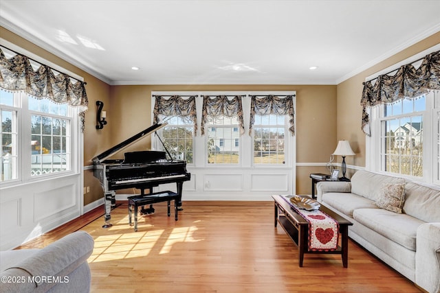 living area with ornamental molding, light wood-type flooring, and recessed lighting