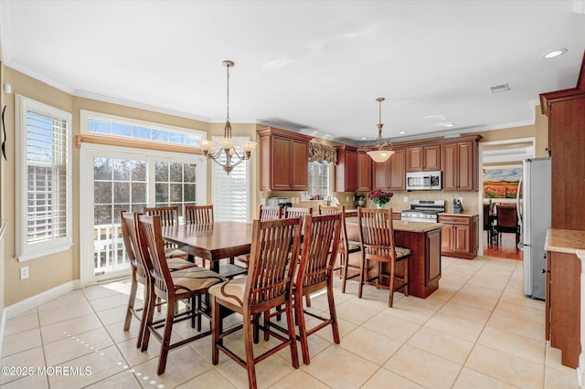 dining room with light tile patterned floors, a wealth of natural light, visible vents, and crown molding