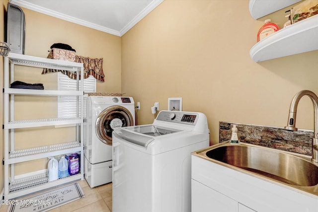 laundry area with light tile patterned floors, laundry area, a sink, washer and clothes dryer, and crown molding