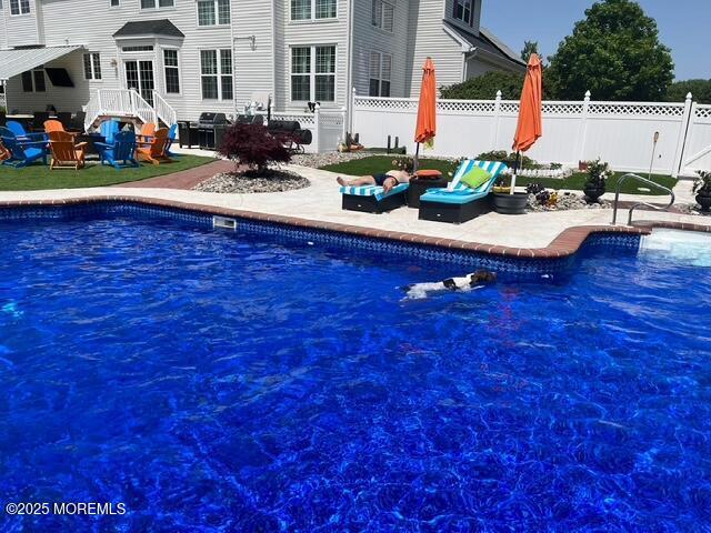 view of swimming pool featuring a patio area, fence, and a fenced in pool