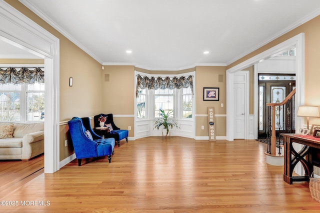 living area with light wood-style flooring, recessed lighting, baseboards, stairs, and crown molding