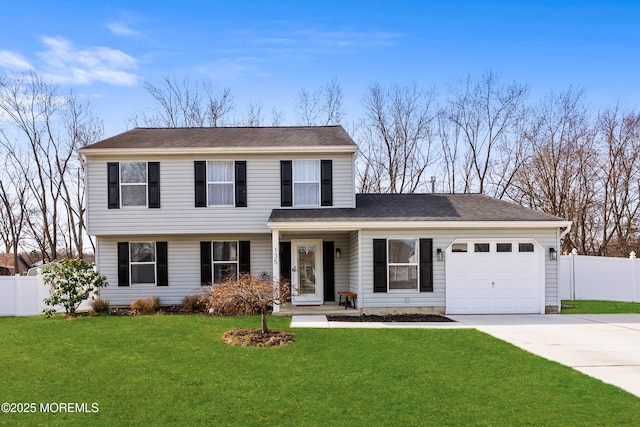 colonial house featuring fence, an attached garage, a shingled roof, concrete driveway, and a front lawn