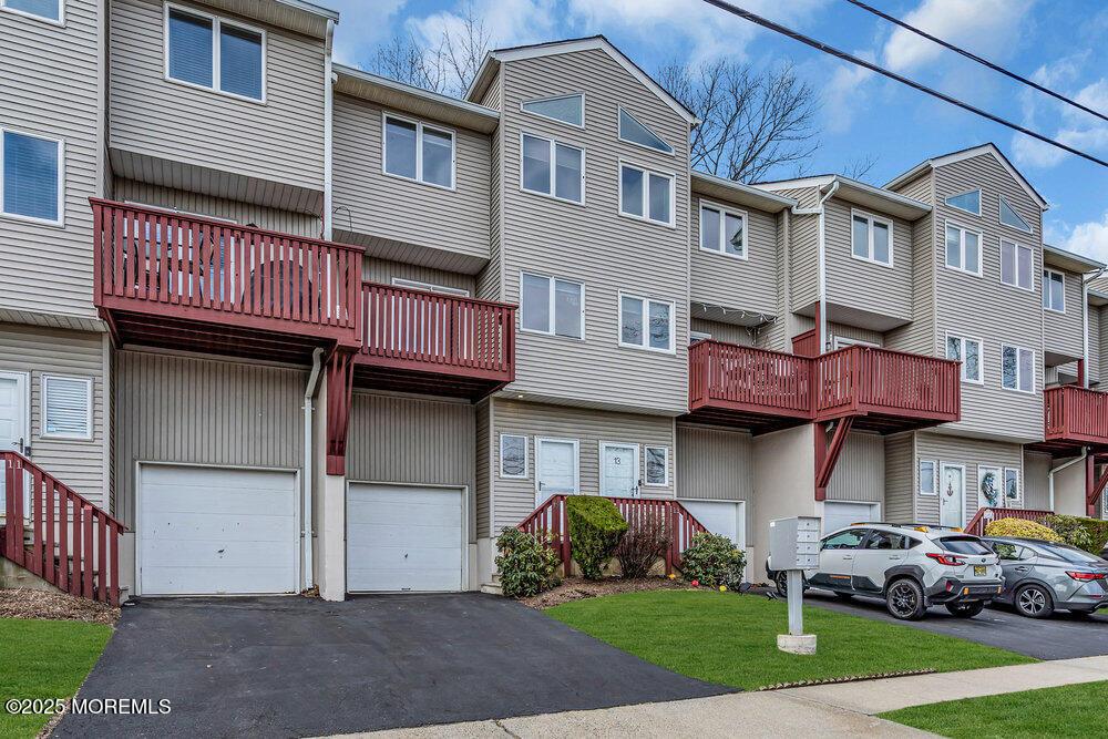 view of front facade with a garage, a residential view, and aphalt driveway