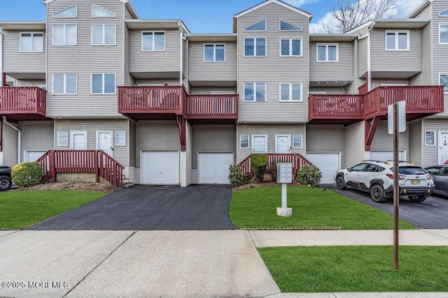 view of front of house with driveway, an attached garage, and a front yard