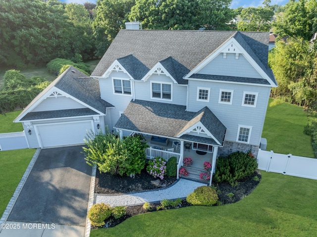 view of front of home with covered porch, roof with shingles, an attached garage, and a gate