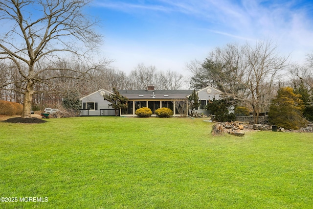 back of property with a yard and a sunroom