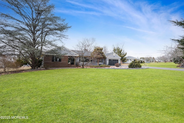 ranch-style home with brick siding, a front lawn, an attached garage, and driveway