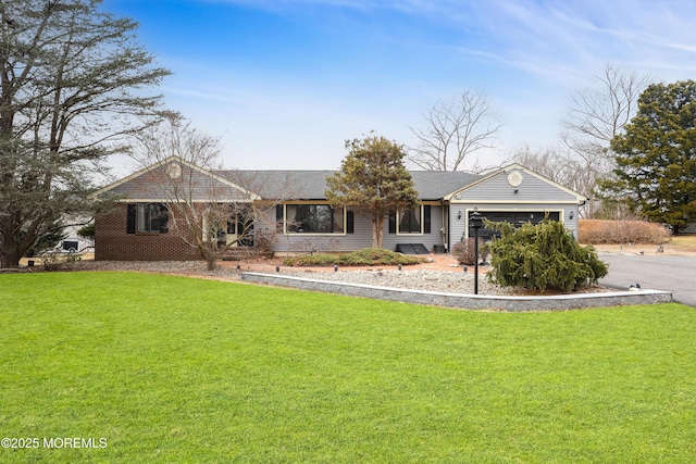 single story home with an attached garage, driveway, and a front yard